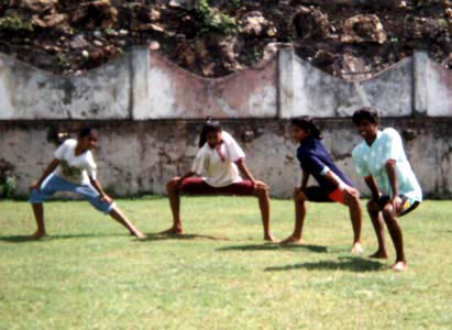 children playing ball in a park setting with brick wall