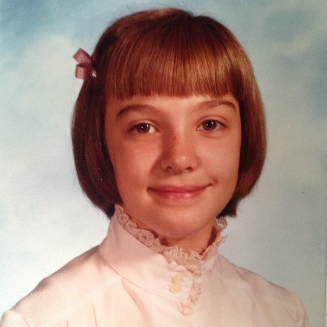 a very cute young lady with bangs wearing a blouse