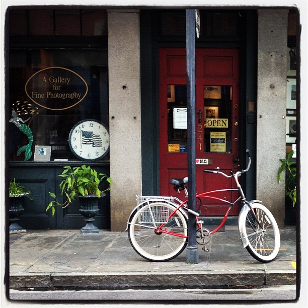 red bike sitting on the sidewalk outside a restaurant