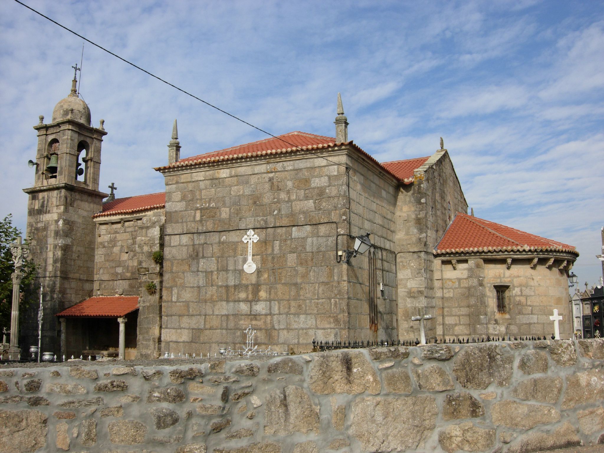an old church building sitting on top of a stone wall