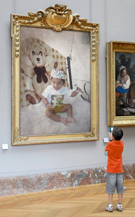 there is a little boy looking at two paintings