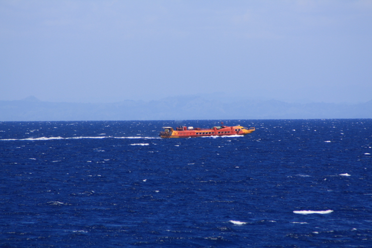 the orange boat is floating in the ocean