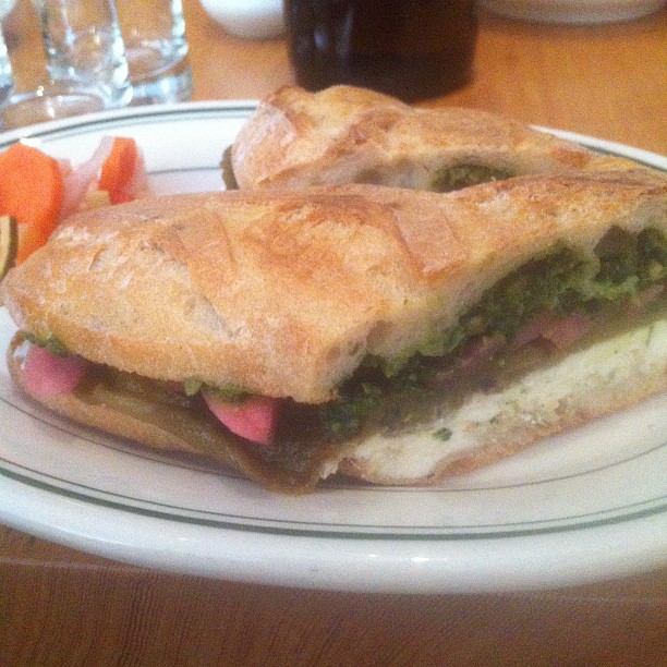 the luncheon has a sandwich with carrots and green vegetables