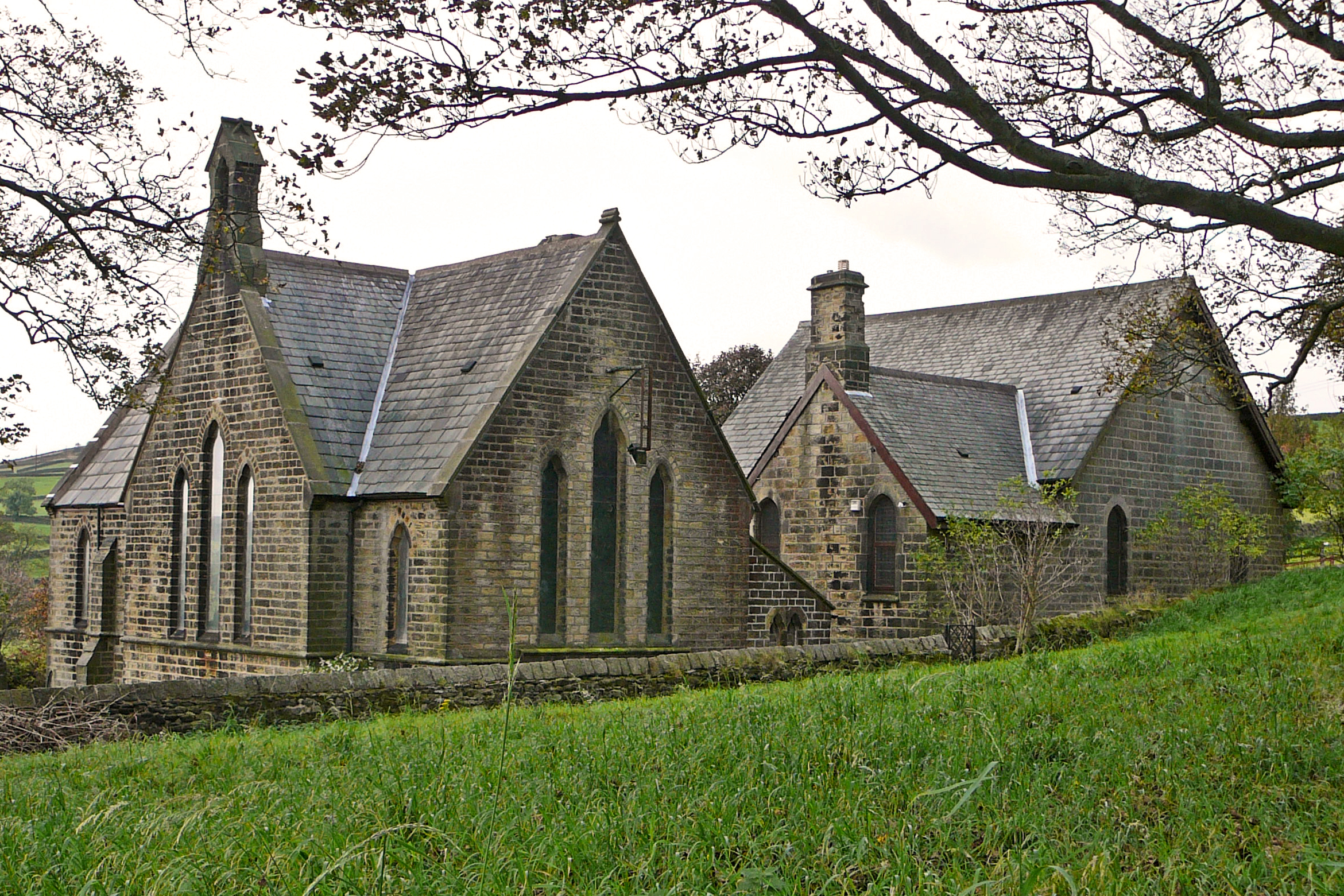 a stone church in a grassy area