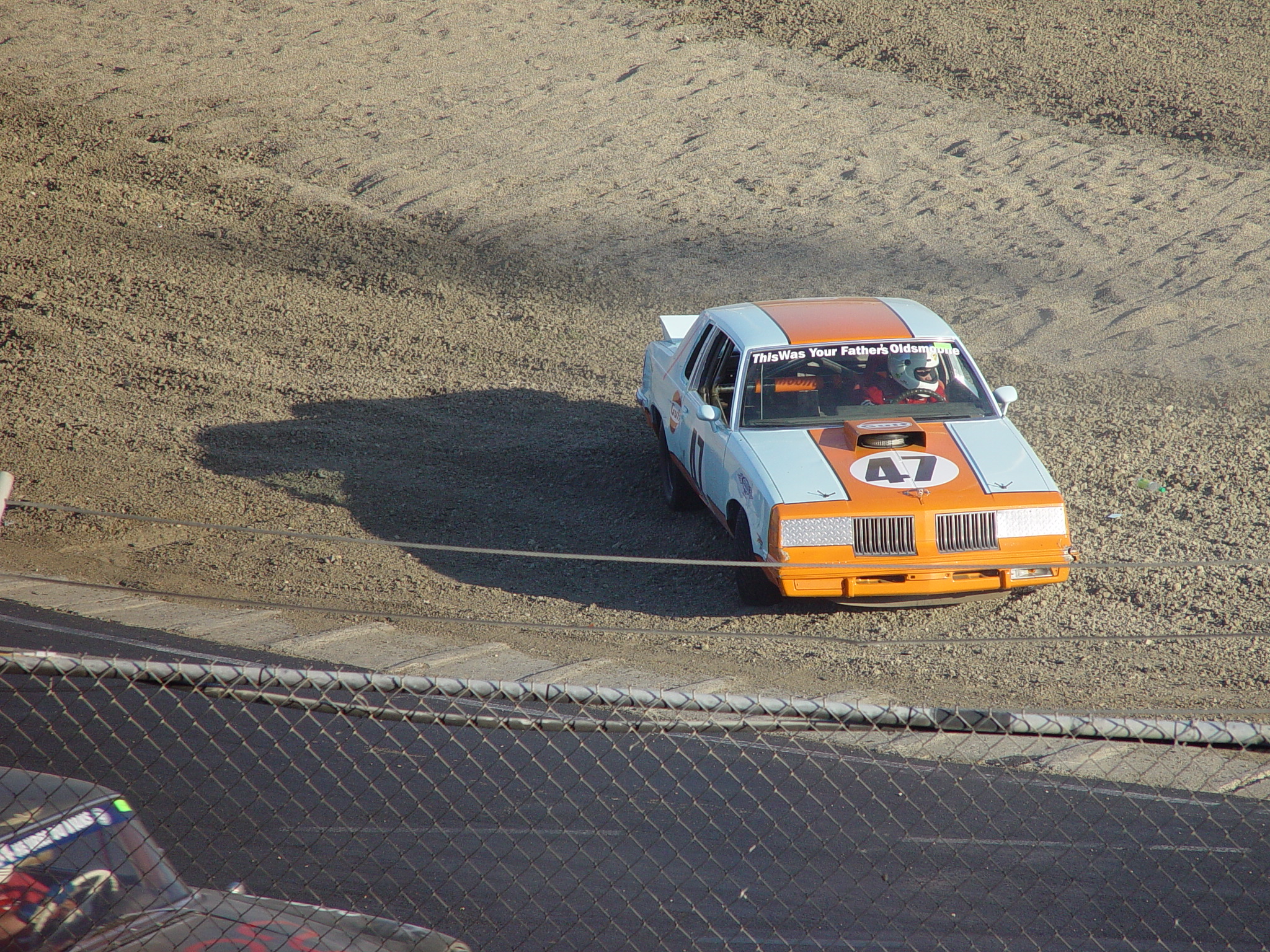 an orange and blue race car sitting on top of a track