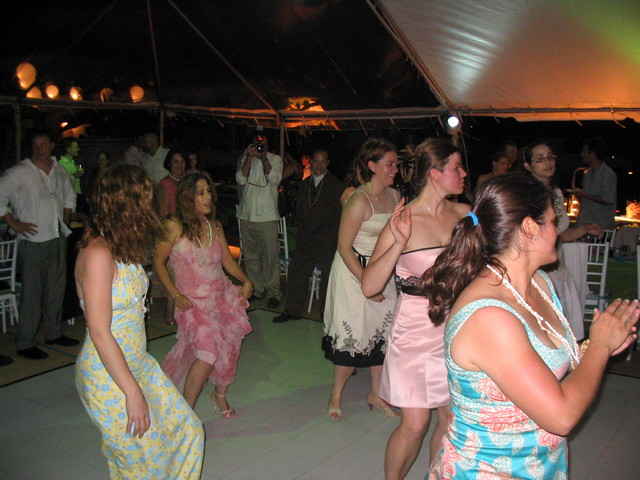 many people dancing in formal attire at a party
