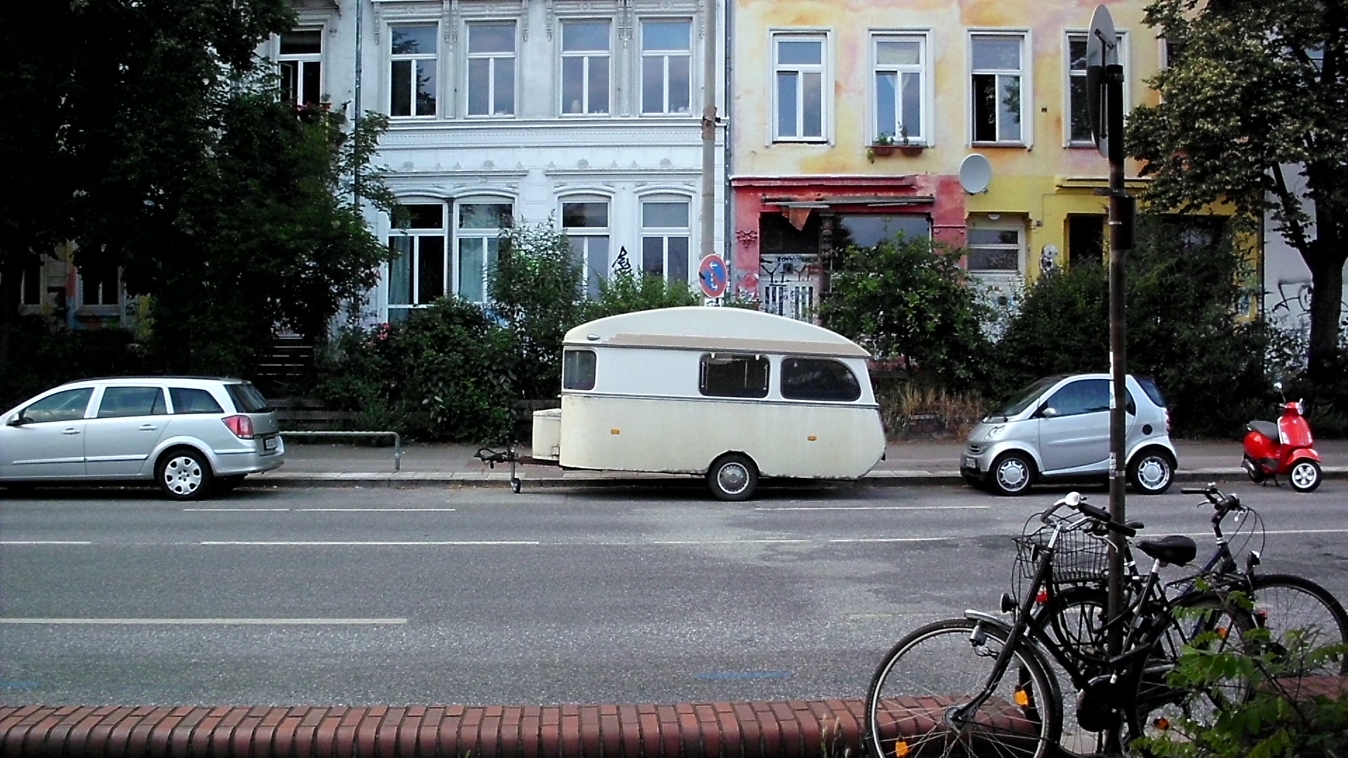 a parked motor home sits in front of parked cars