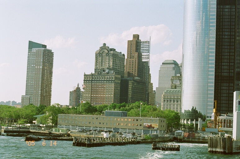 a cityscape seen from the water, with boats floating on the water