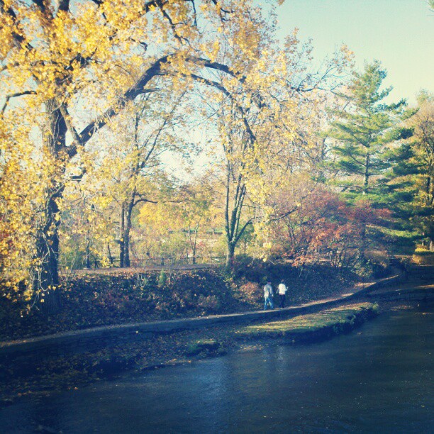 two people walking down the path by a body of water