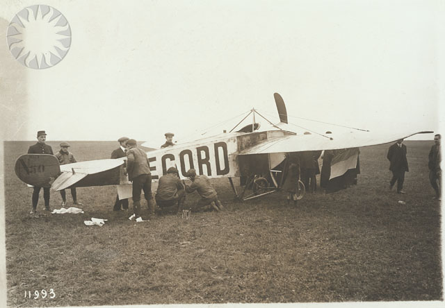 a group of people standing around a small airplane