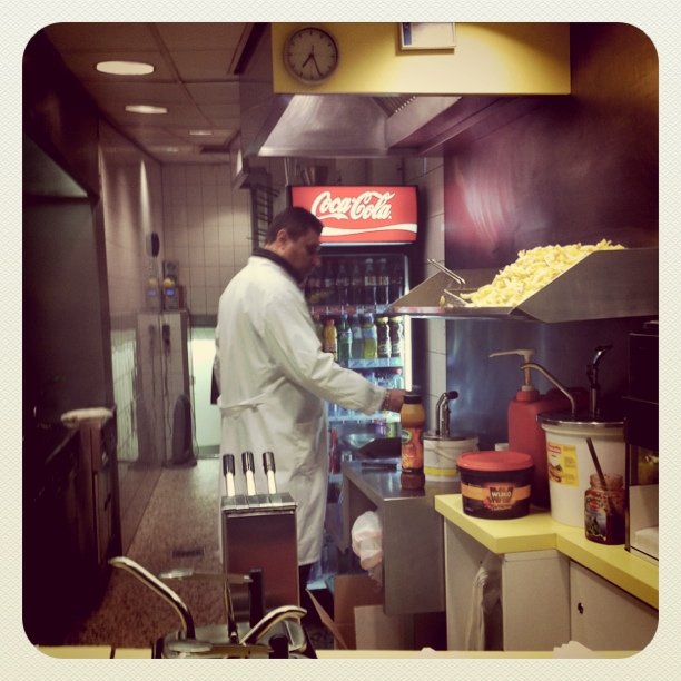 a man preparing food inside of a kitchen