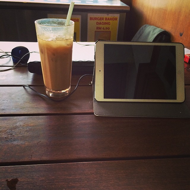 a tablet on the table next to a drink