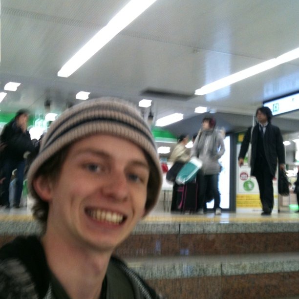 a smiling man is wearing a hat at the airport