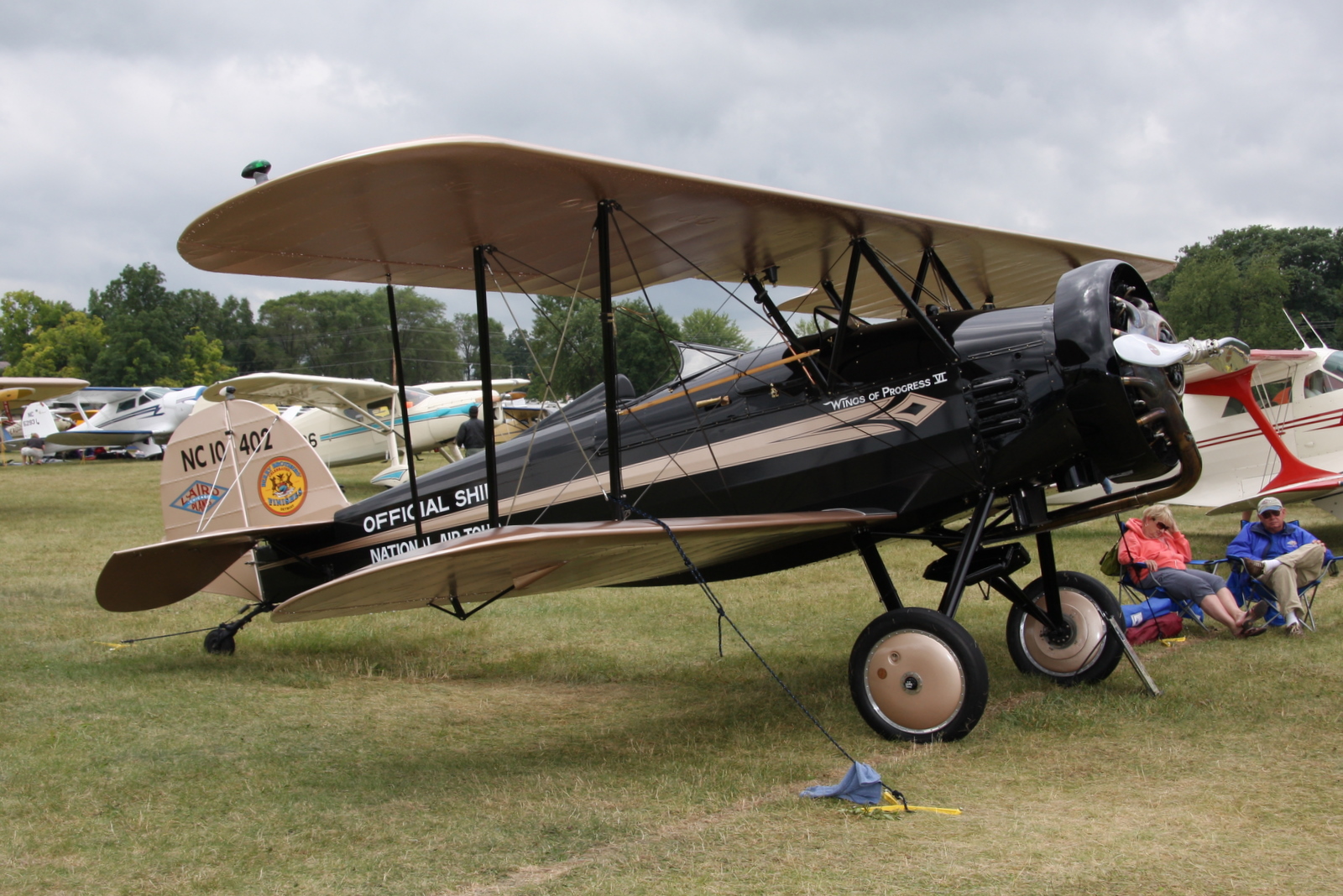 a man and his s sit next to an old airplane