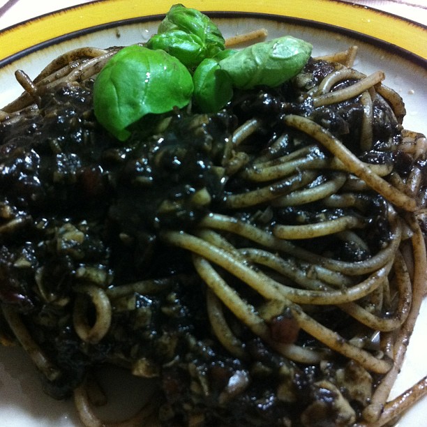 a plate with a bunch of cooked spaghetti and mushrooms on it