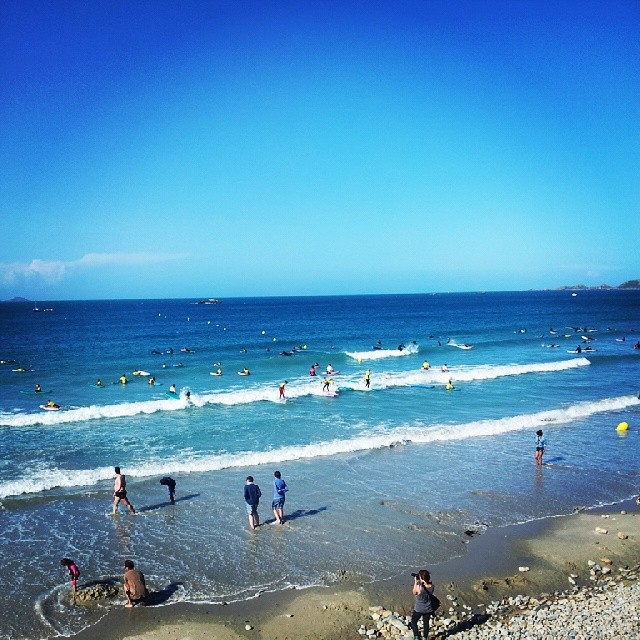 a view of many people playing in the ocean waves
