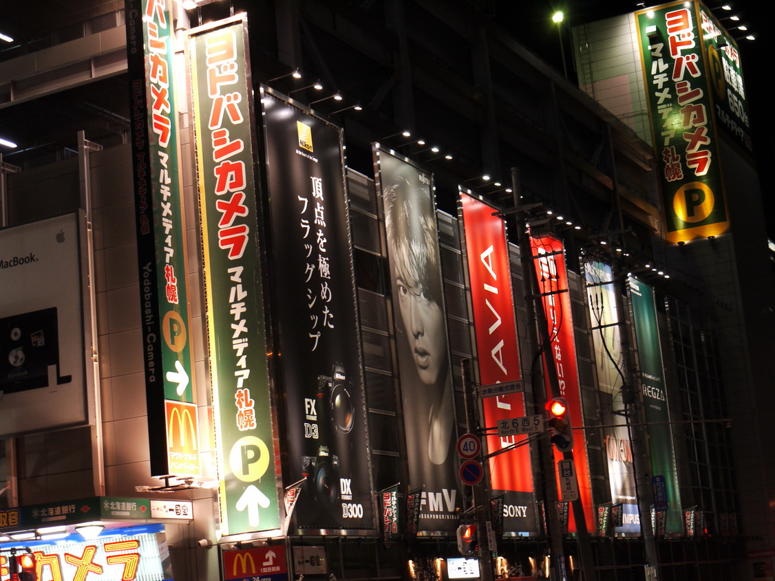 a building that has many colorful signs lit up at night