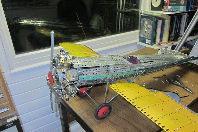 a plane made out of metal sitting on a desk