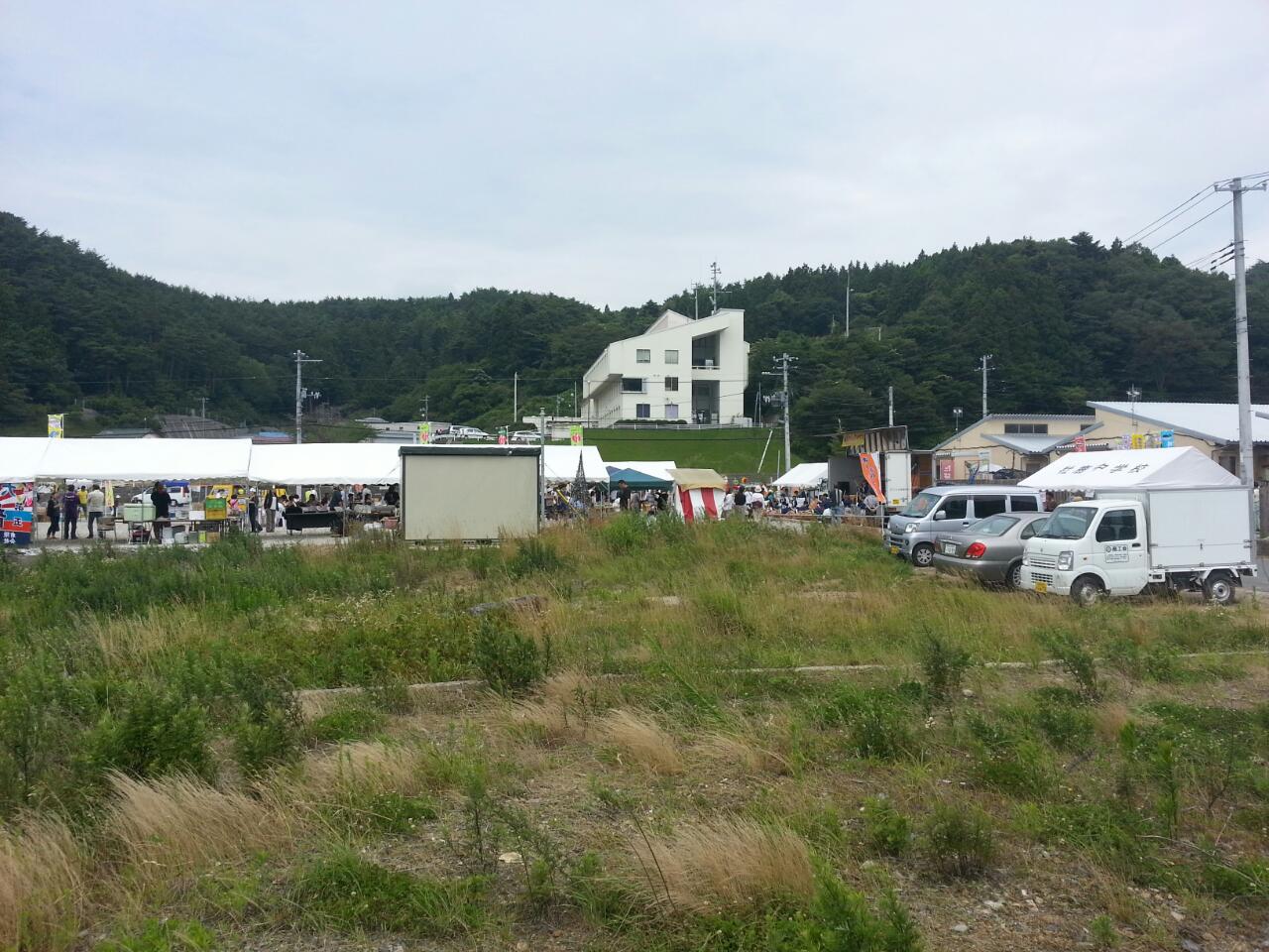 several vehicles parked near a fence and some mountains