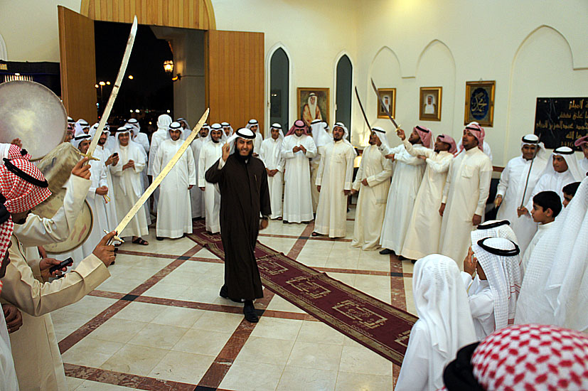 a man dressed in white standing next to a large crowd of people