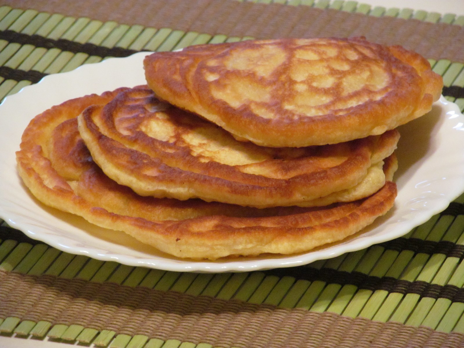 a white plate topped with five pancakes on a counter