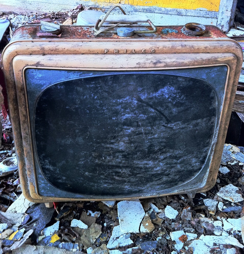 an old television left on the ground among some rubble