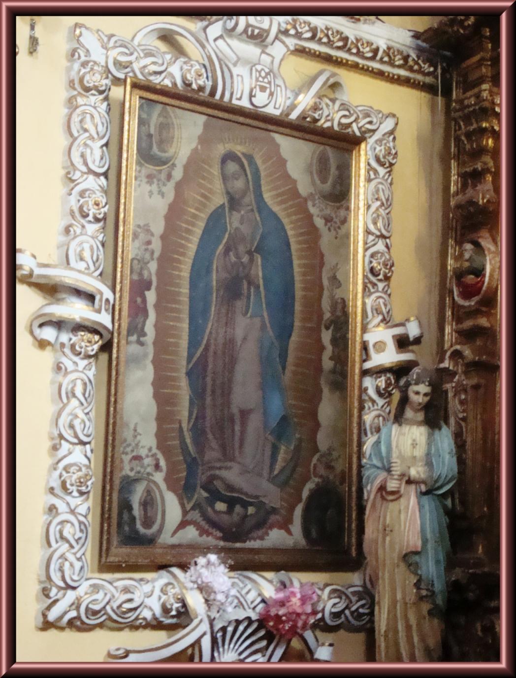 a picture of the virgin mary on a wall in a room