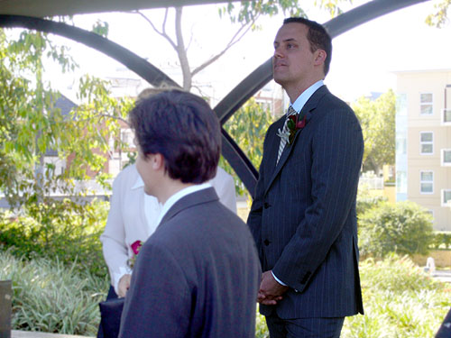 a man standing by another man at a wedding
