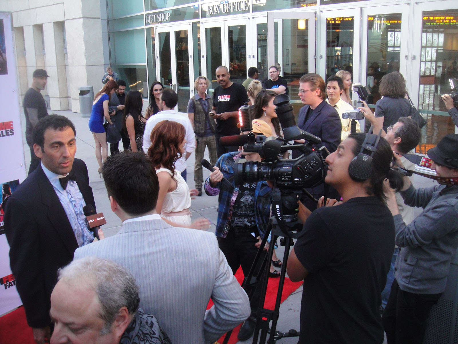 the camera man is filming two people on the red carpet