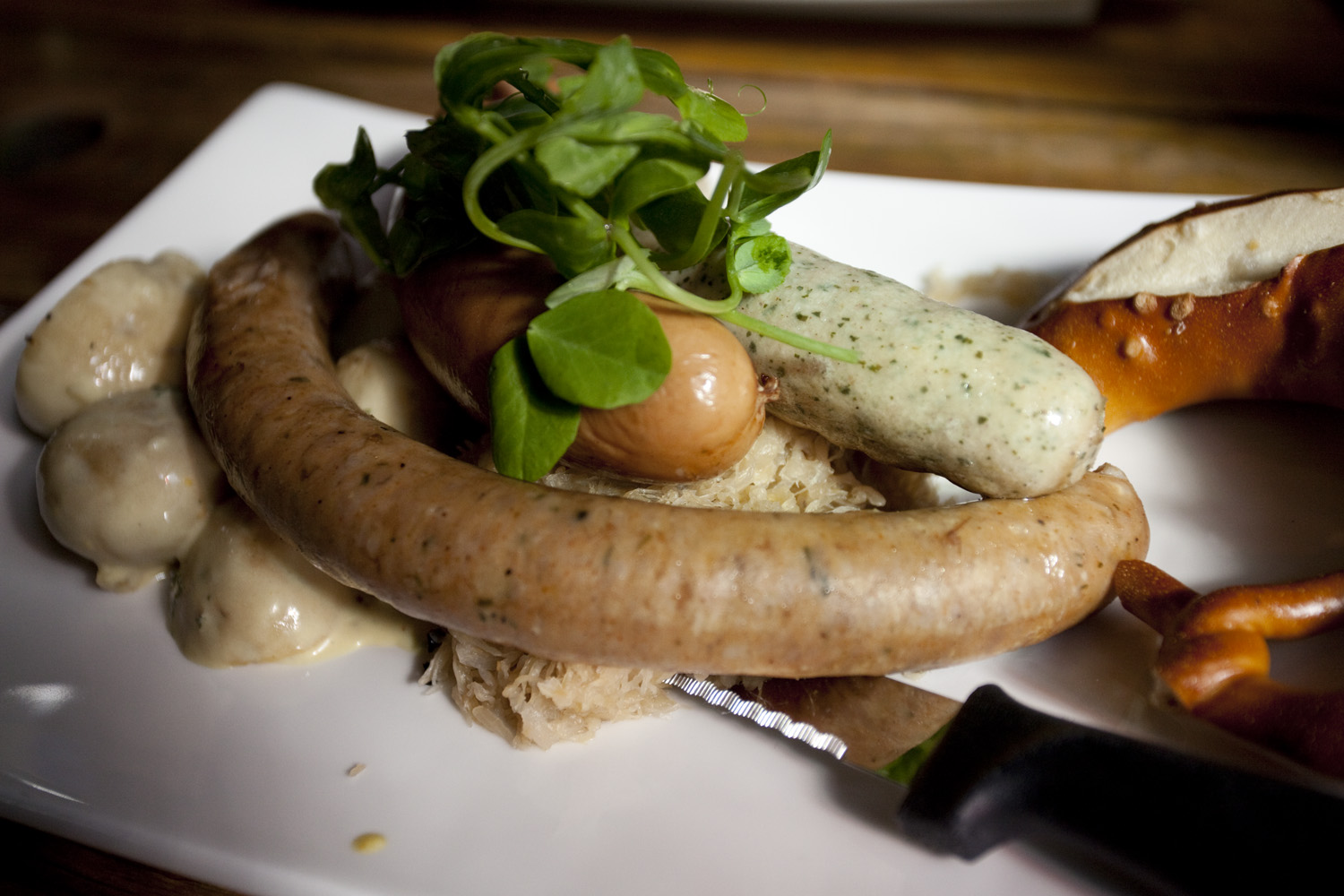 sausages and mushrooms served on a plate with a knife