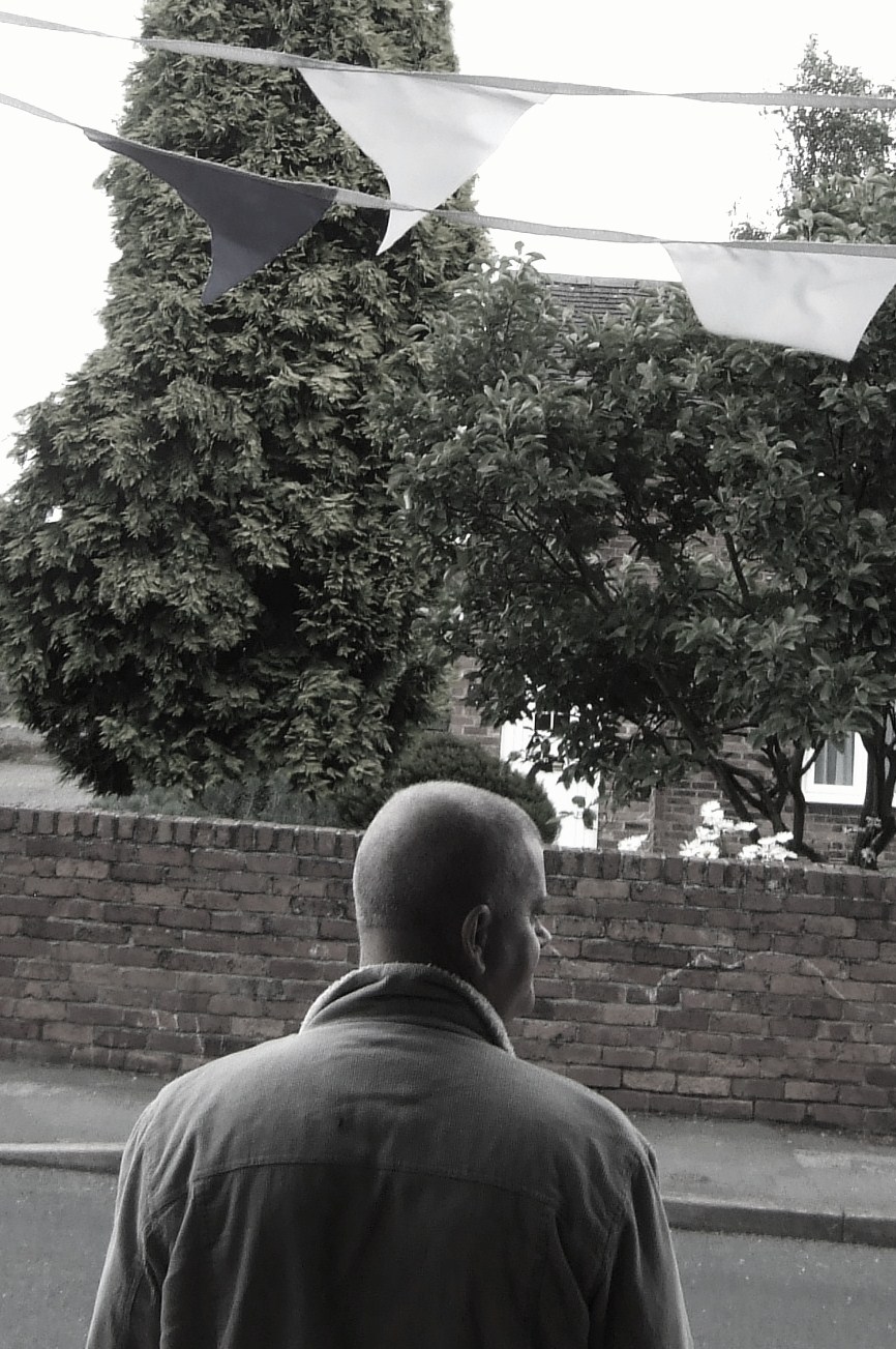 a man walking on the street past some paper kites