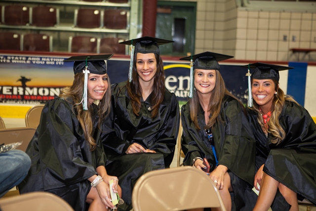 three women dressed in graduation gowns sitting next to each other