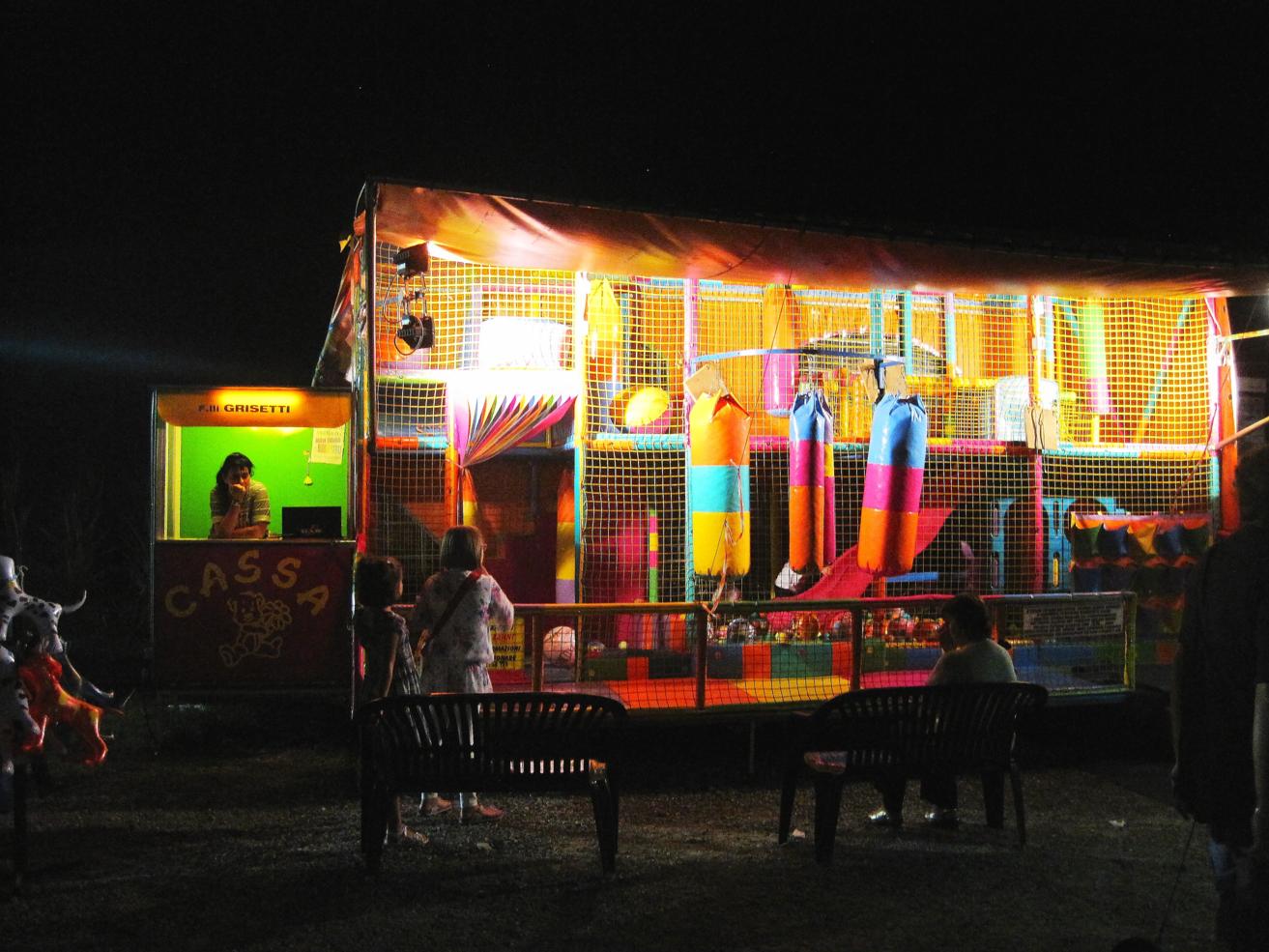 an illuminated carnival booth in the dark