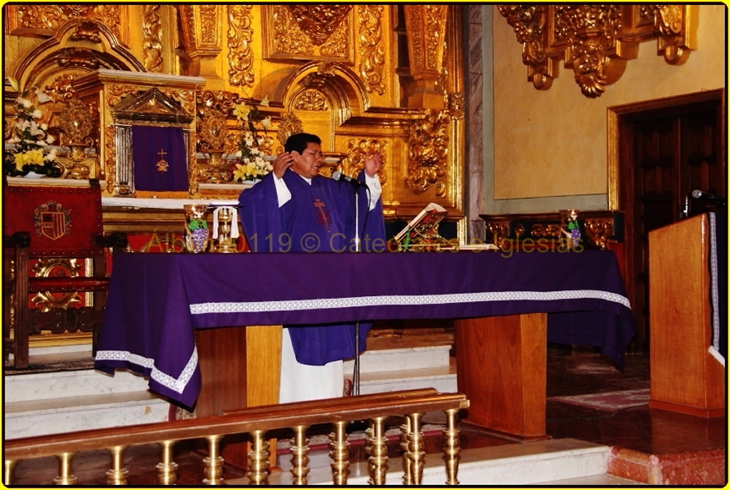 the priest is standing in front of a altar with purple cloth