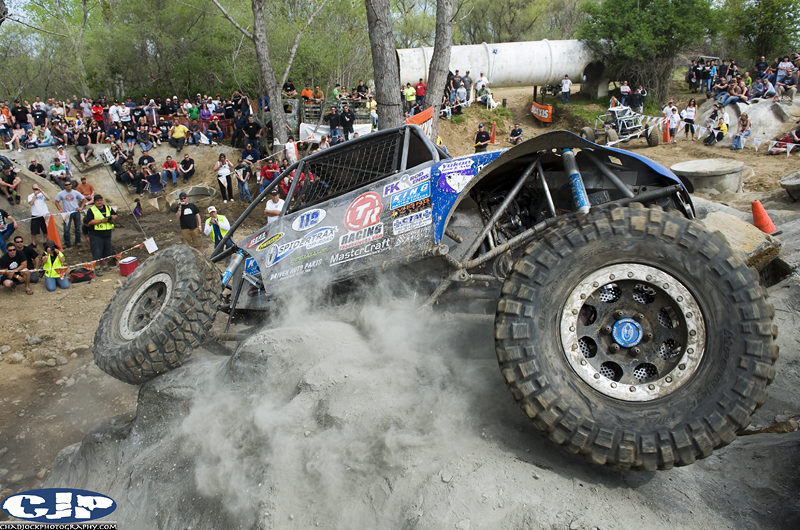 there is a large blue monster truck going over rocks