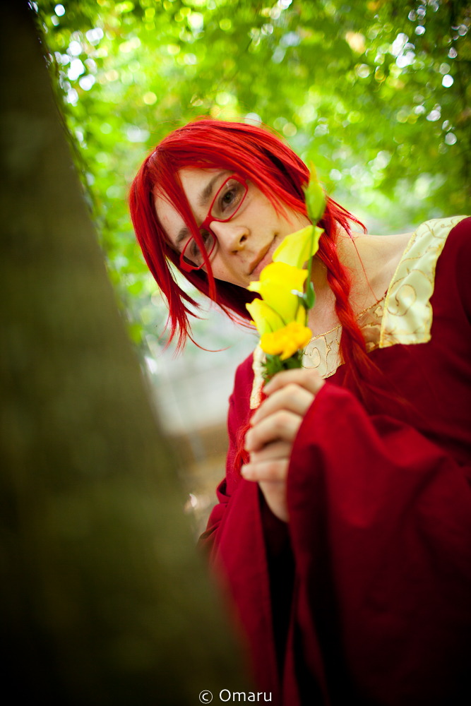 a girl with red hair and glasses with a yellow flower in her hand