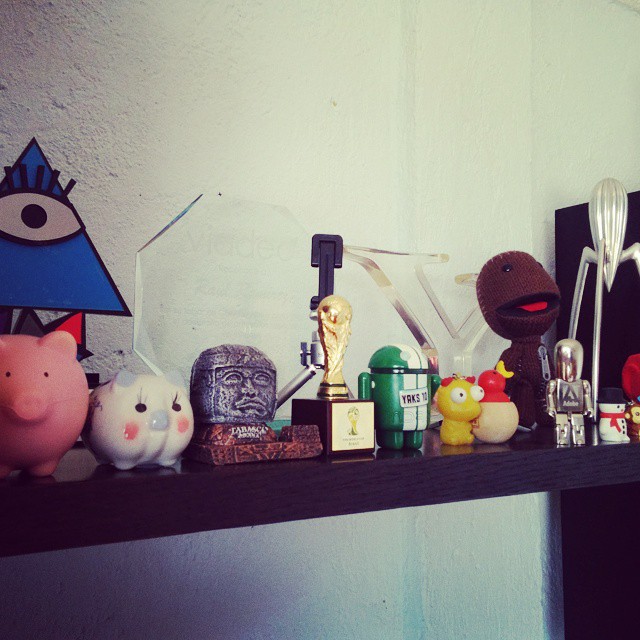 many figurines are on a shelf against a wall