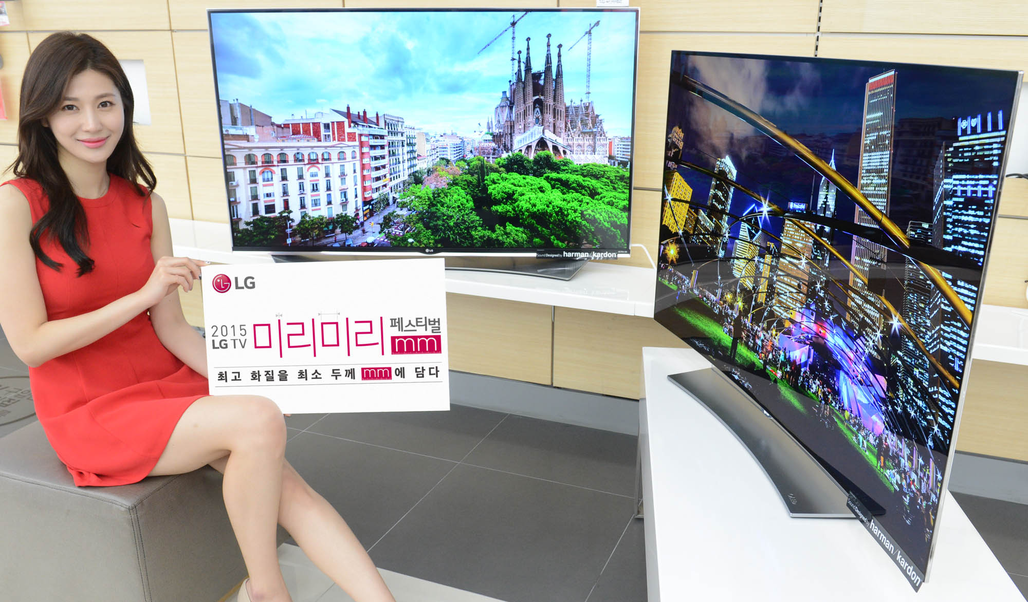 a girl is sitting on the edge of a platform in front of televisions