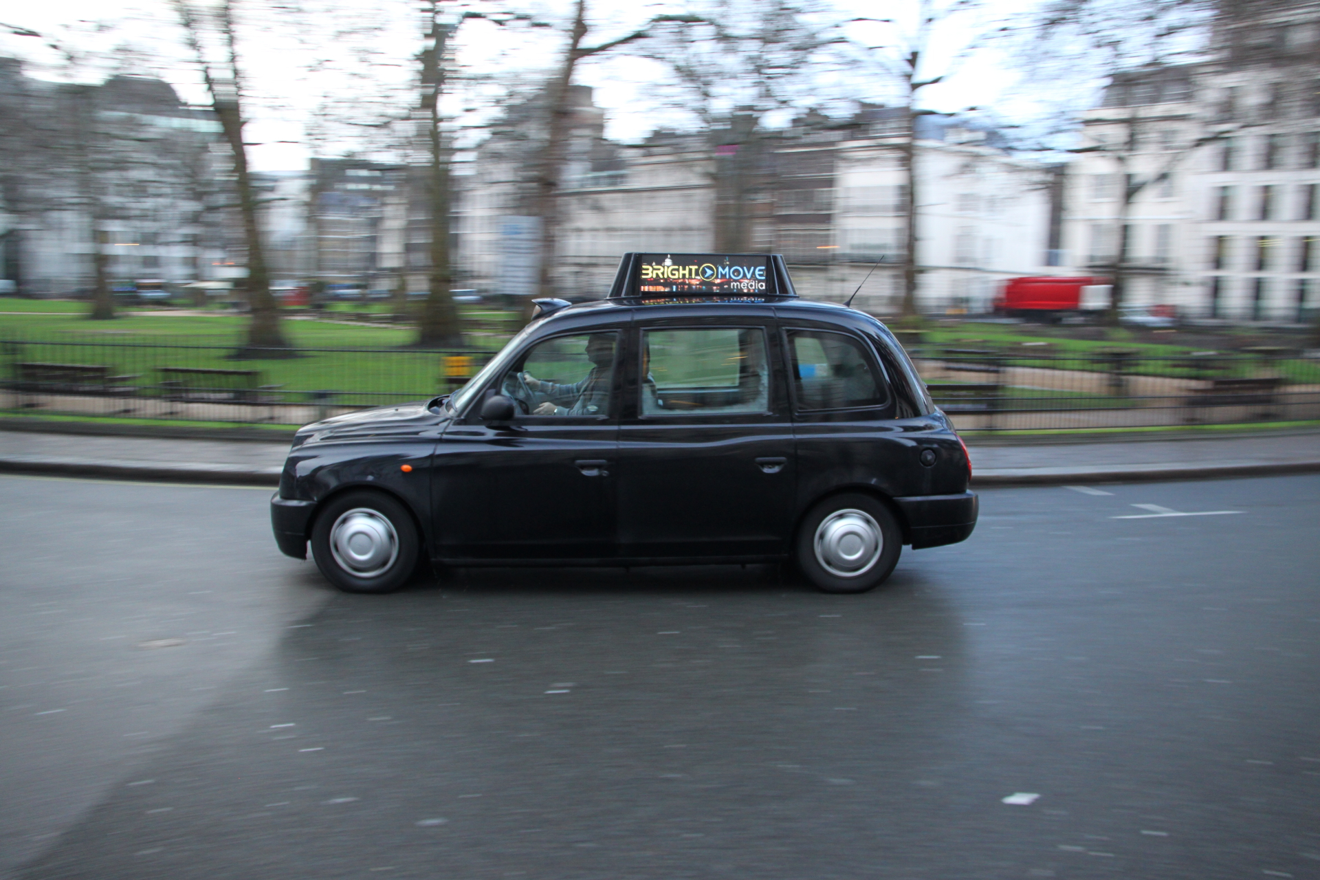 an image of a black taxi driving down the street