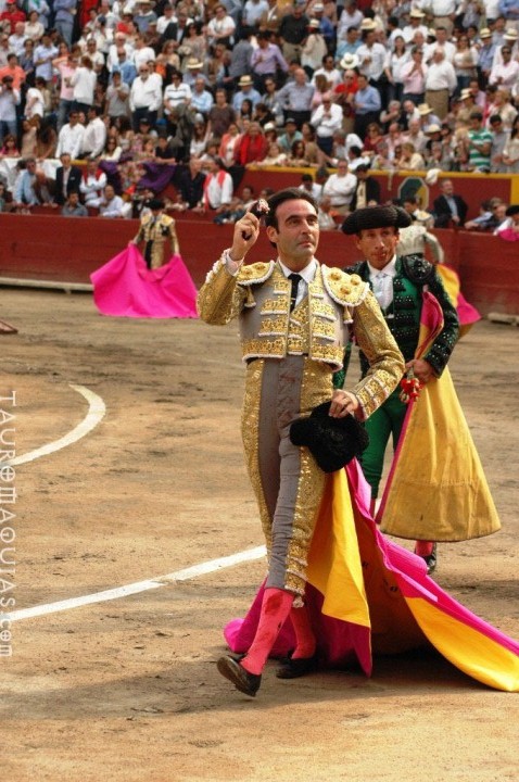 a bullfighter on a phone at a bullfight