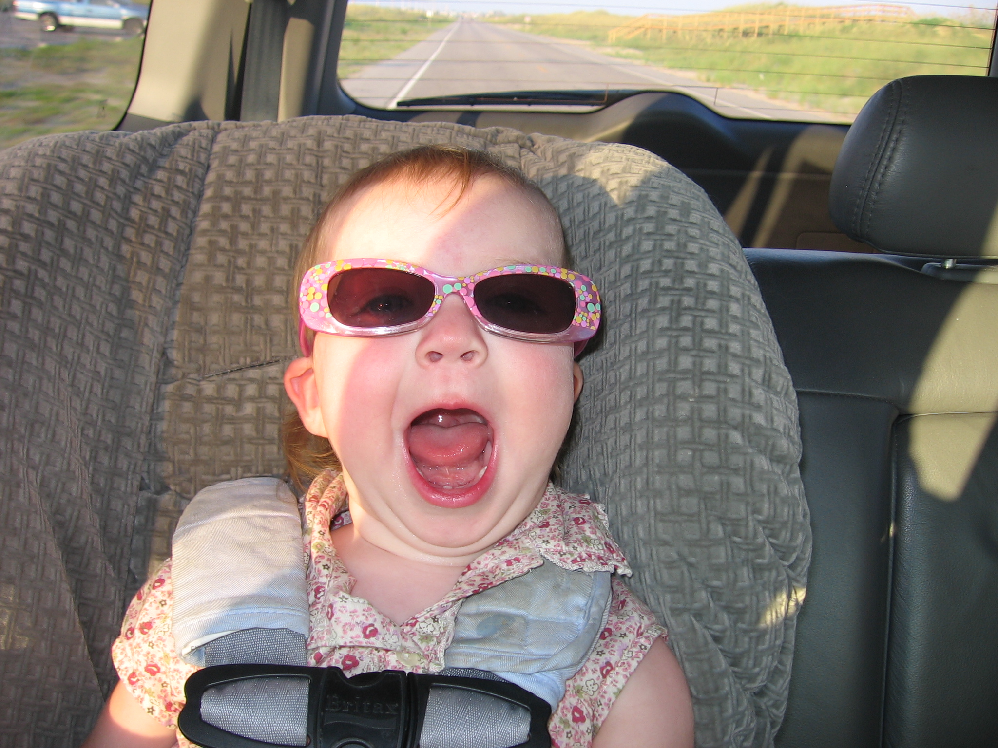 the baby is dressed in sunglasses in the car