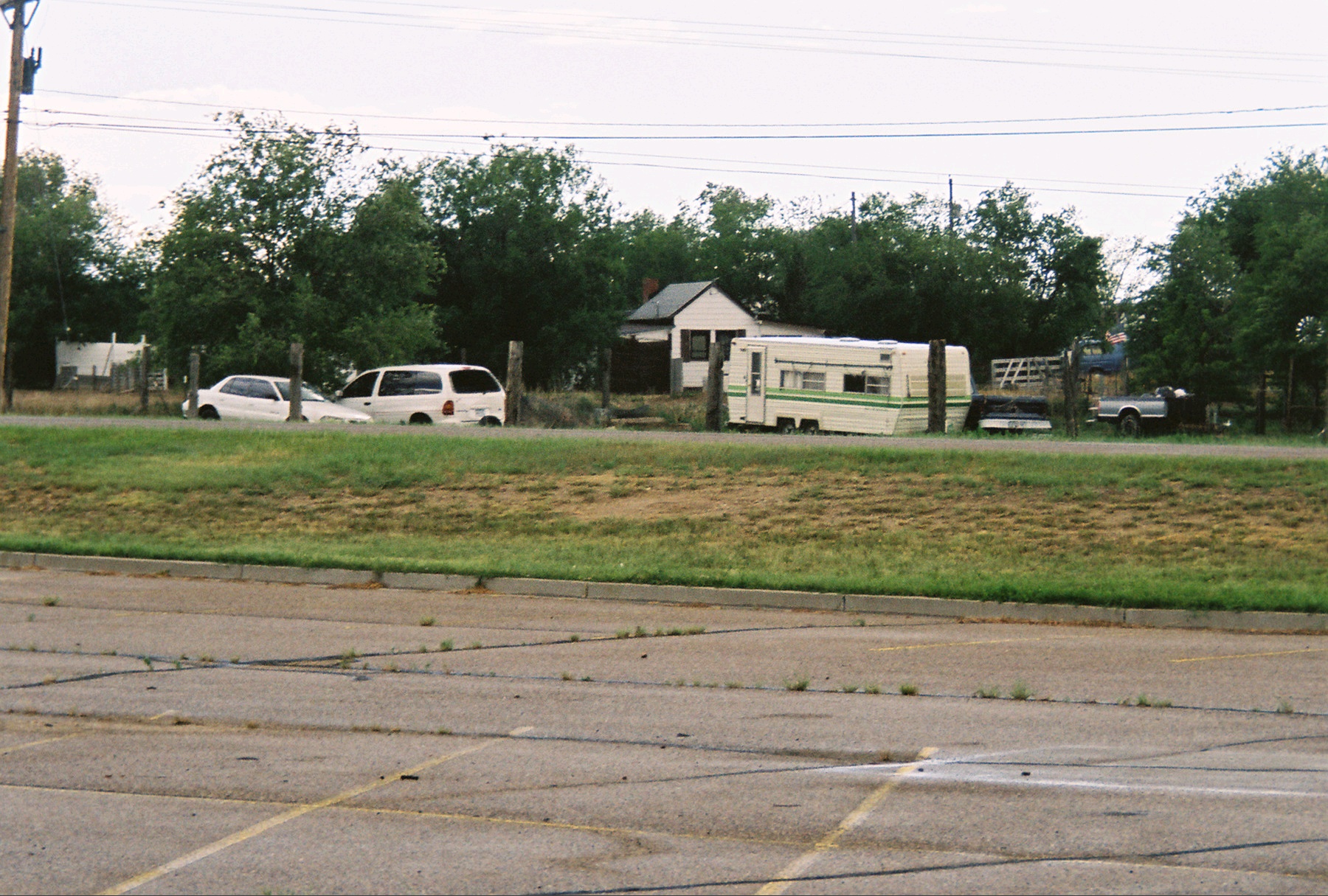 two buses and some vans are parked in a yard