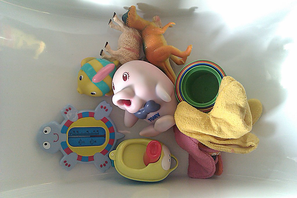 a toy elephant, toothbrushes, cup, stuffed animals, and other items