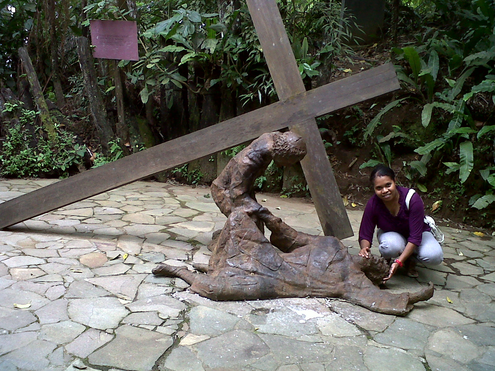 a child squatting next to a wooden cross