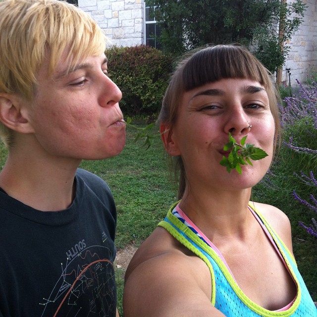 two young people with leaf in their mouths