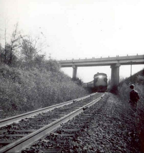 a train crossing a track with a person standing next to it