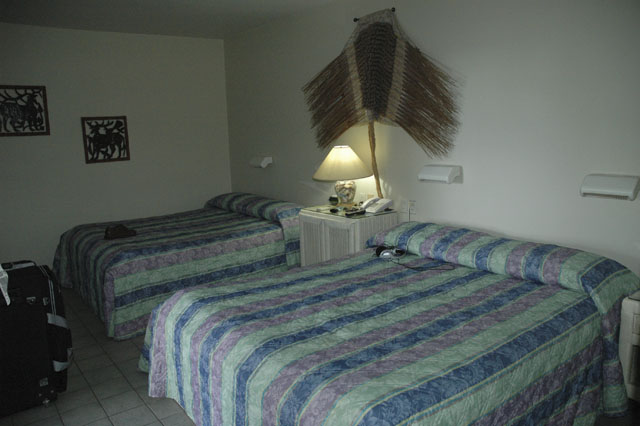 the two beds are made with multicolored blankets