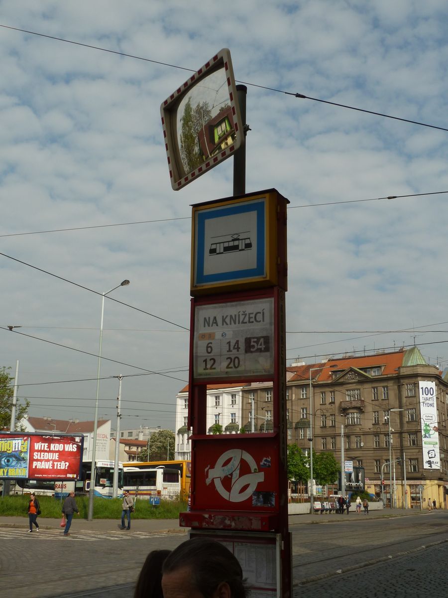 people are sitting next to a sign in a street