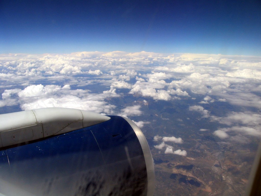 an airplane view looking down on a few fluffy clouds