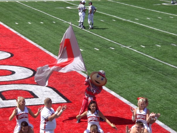 a mascot and cheerleaders on a football field